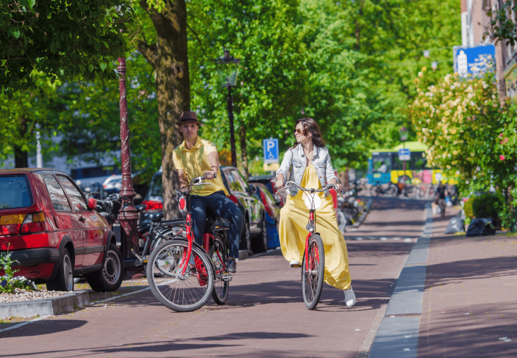 Young happy caucasian couple on bikes in old streets in Rotterdam