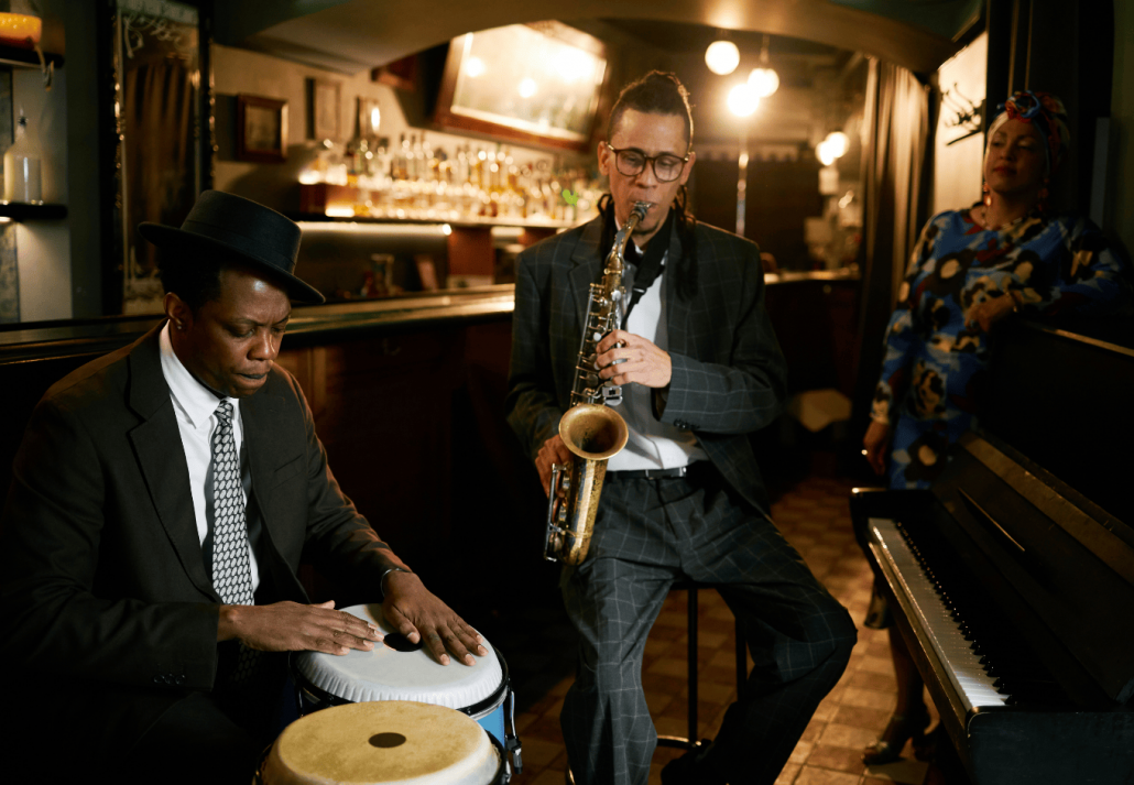 Male Conga Drummer And Saxophonist Playing Instruments in Jazz Club