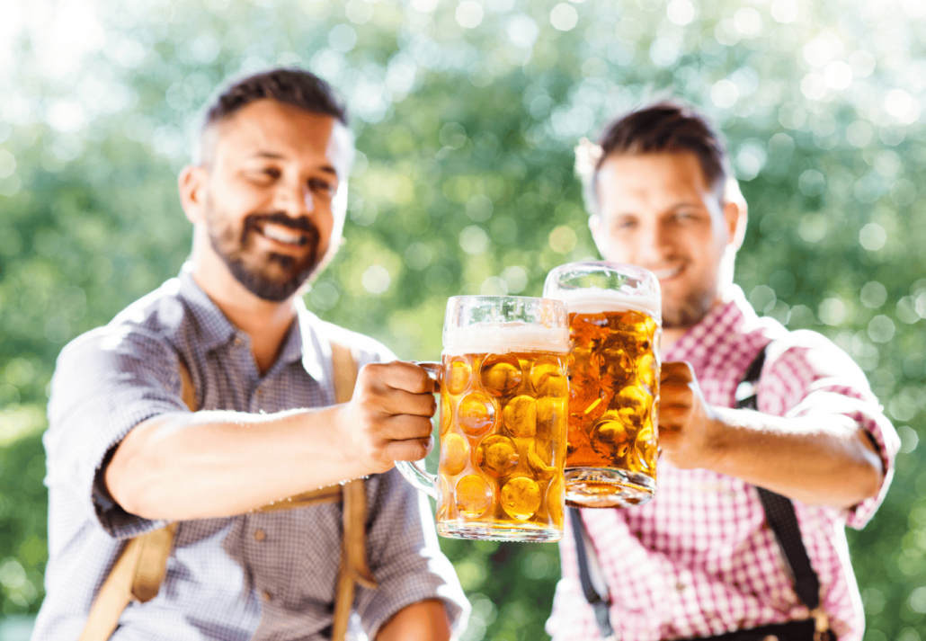 Men in traditional bavarian clothes holding mugs of beer