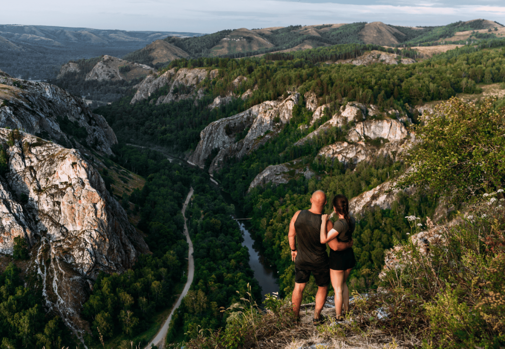 A couple meets the sunrise in the mountains, rear view. Man and woman in the mountains