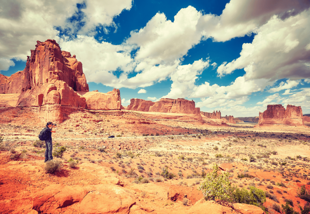 Female photographer takes pictures in Arches National Park.