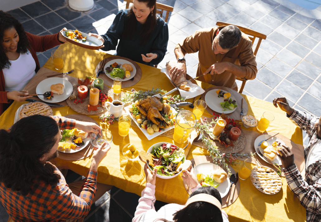 Happy diverse male and female friends eating thanksgiving celebration meal in New York